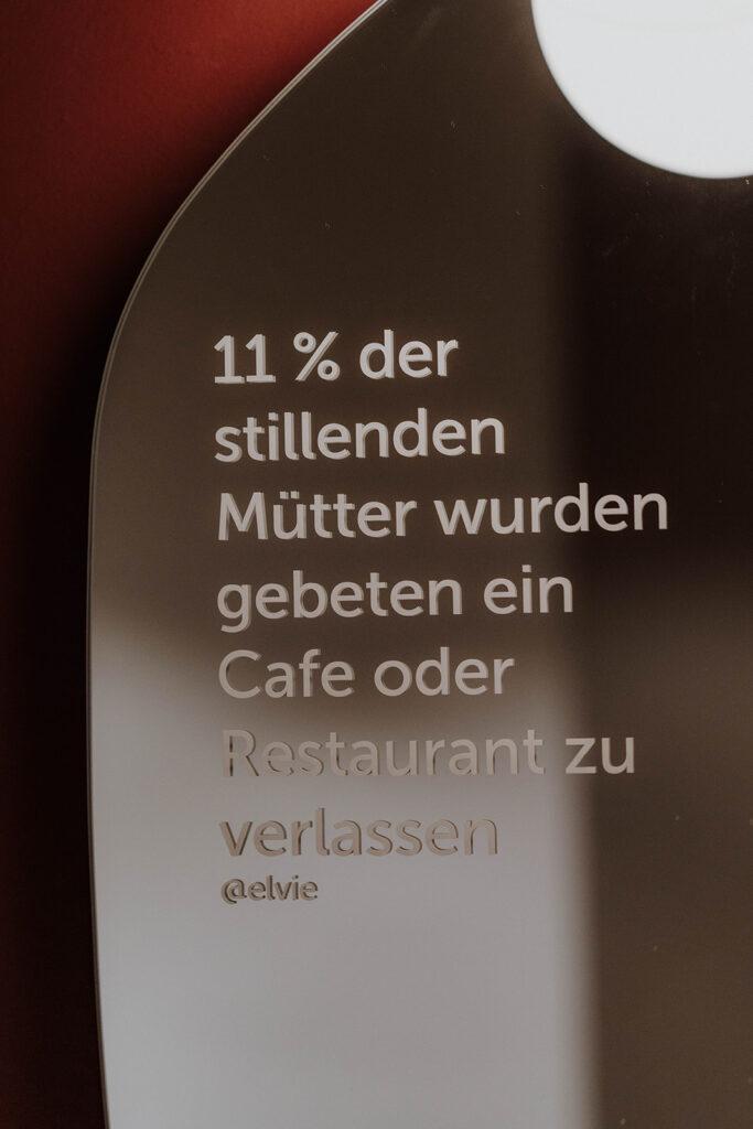 Ein Text aufgeklebt auf einem Spiegel. Dort steht: 11 Prozent der stillenden Mütter werden gebeten, ein Café oder Restaurant zu verlasen.