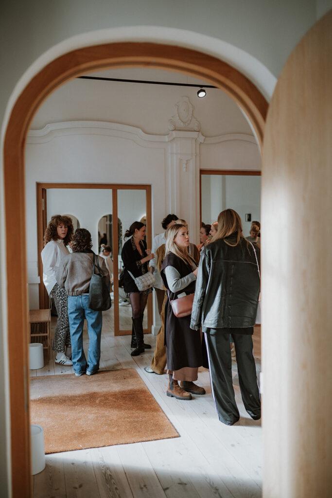 Eine Gruppe Frauen in einem großen Altbau-Voraum, die sich unterhalten.